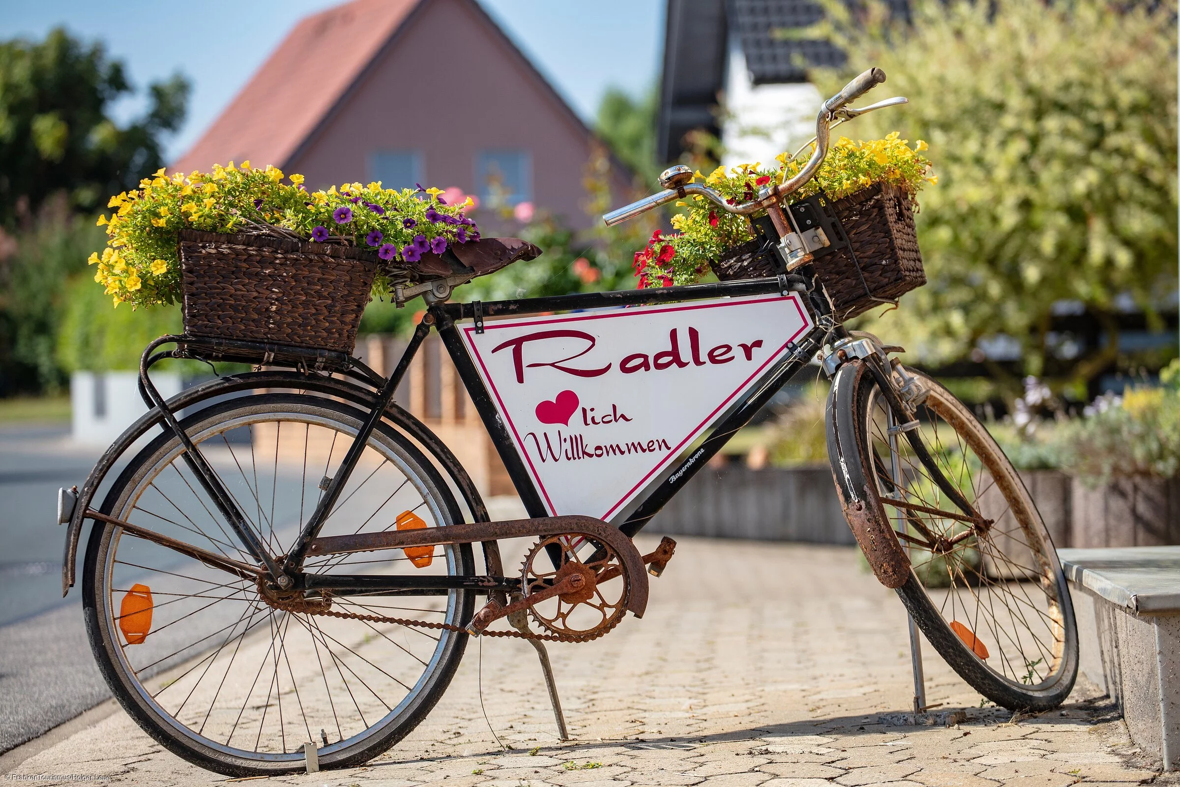 Ein altes Fahrrad, aufbereitet zu einem herzlichen "Willkommens-Schild" für Radler