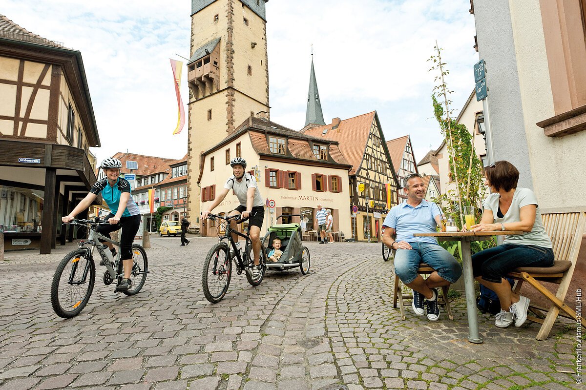 Radfahrer in der Lohrer Altstadt mit Blick auf den Bayersturm