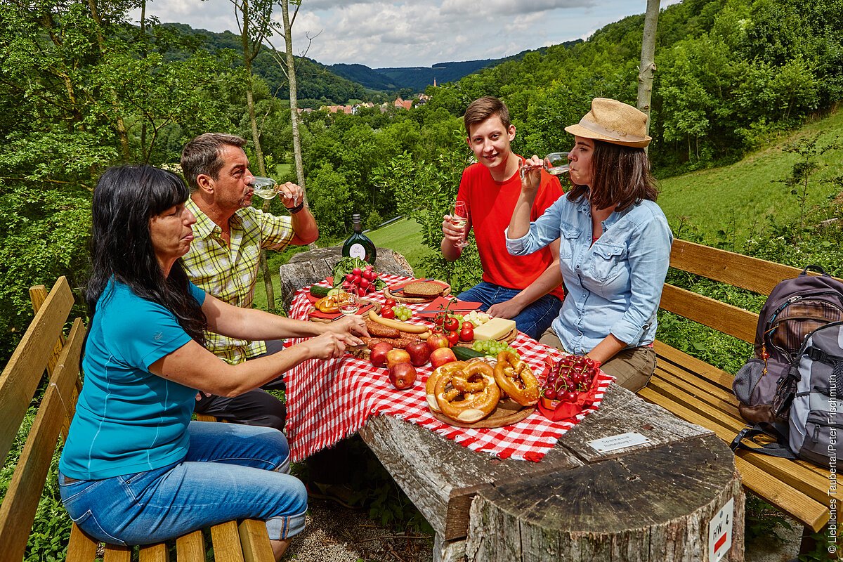 Wanderer an einem Rastplatz in Bettwar mit Blick ins Taubertal