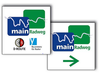 Beschilderung MainRadweg Zwei Schilder mit dem Schriftzug „main Radweg“, eines mit D-Route 5 und Bayernnetz-Logo, das andere mit grünem Pfeil nach rechts.